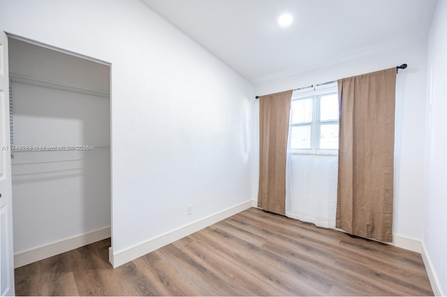 unfurnished bedroom featuring wood finished floors and baseboards