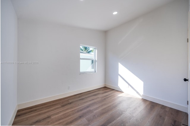 spare room with recessed lighting, wood finished floors, and baseboards