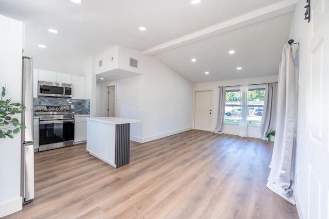 kitchen with stainless steel appliances, light countertops, visible vents, lofted ceiling with beams, and white cabinets