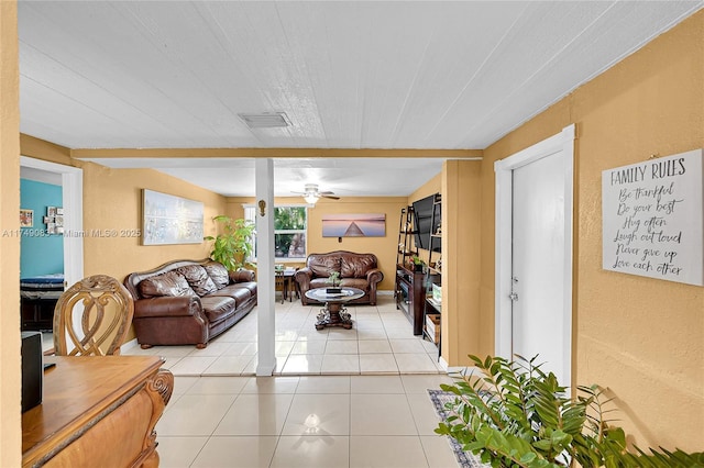 living room featuring light tile patterned floors, ceiling fan, and visible vents