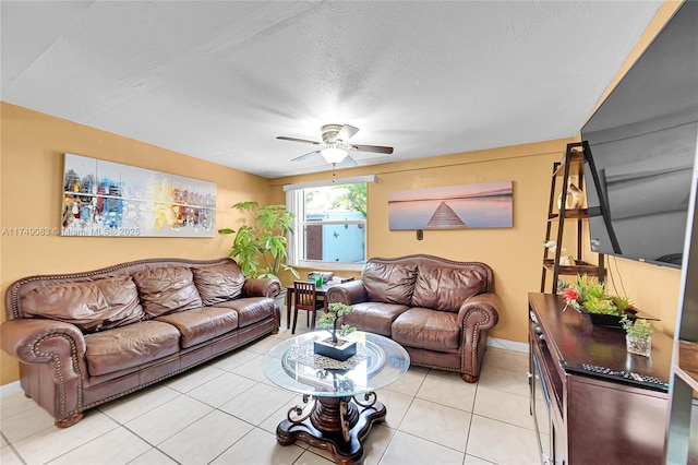 living area featuring light tile patterned floors, ceiling fan, and a textured ceiling