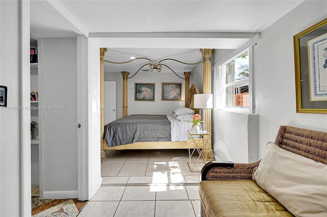 bedroom with light tile patterned floors and beam ceiling