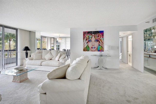 living room with a wealth of natural light, light carpet, and a textured ceiling