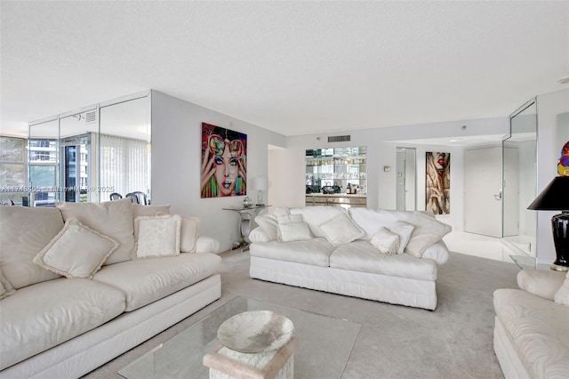 living room with a textured ceiling, carpet flooring, and visible vents