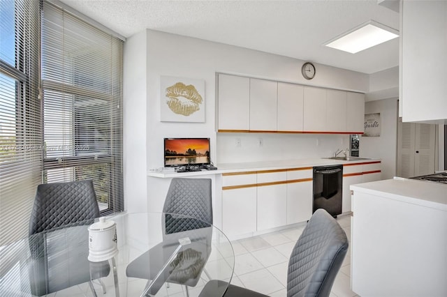 kitchen featuring a sink, a textured ceiling, light countertops, and dishwasher