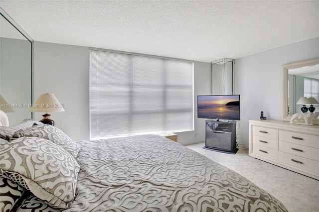 bedroom with light carpet and a textured ceiling