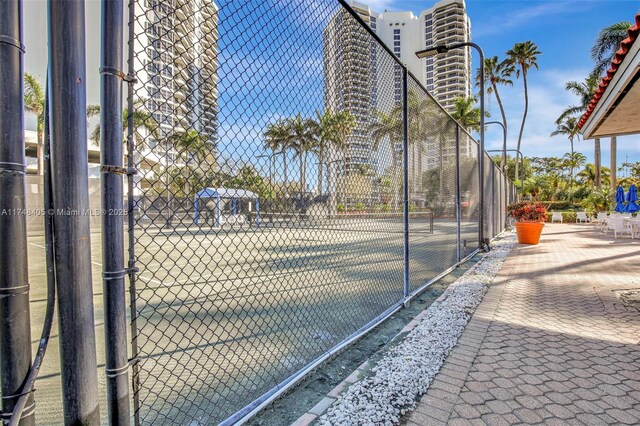 view of tennis court featuring fence