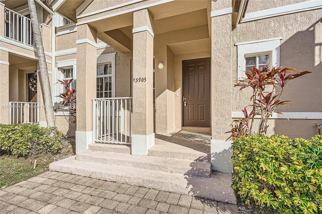 entrance to property featuring stucco siding