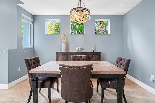 dining room featuring an inviting chandelier, plenty of natural light, and baseboards