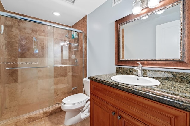 full bathroom featuring visible vents, vanity, a shower stall, and toilet