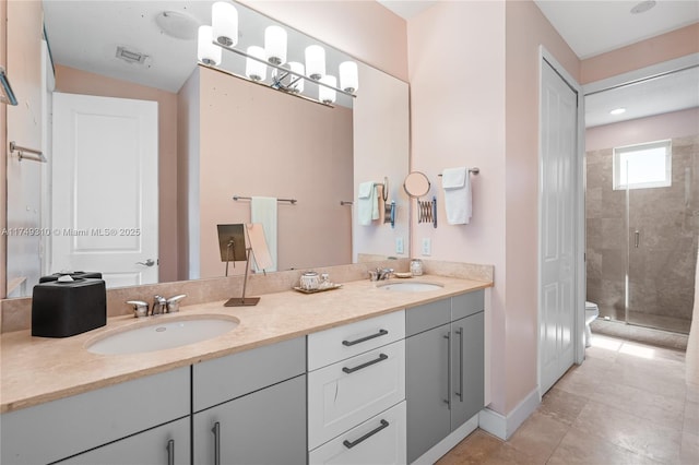 bathroom featuring double vanity, a stall shower, visible vents, toilet, and a sink