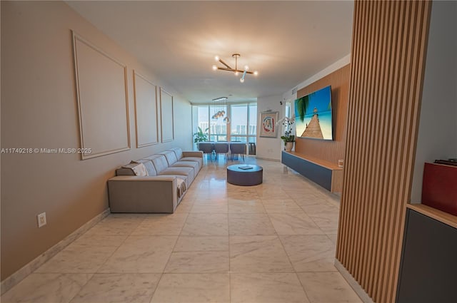 living area with marble finish floor, baseboards, a chandelier, and a wall of windows