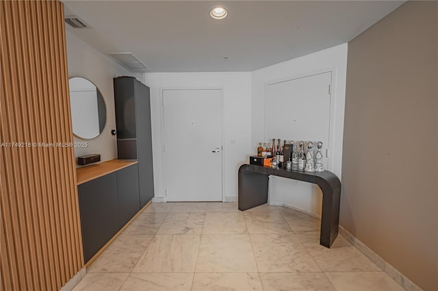 hallway featuring marble finish floor, baseboards, visible vents, and recessed lighting