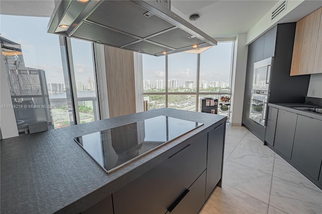 18201 Collins Ave Unit 1201, Sunny Isles Beach, FL 33160 - kitchen featuring island range hood, a city view, stainless steel oven, black electric stovetop, and healthy amount of natural light