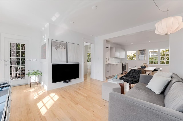 living area with light wood-style floors and recessed lighting