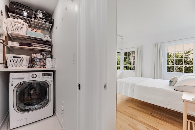 laundry area with washer / dryer, laundry area, and wood finished floors