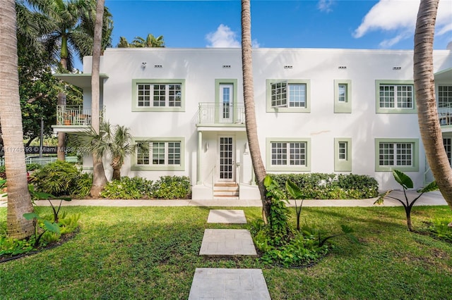 exterior space featuring a yard, a balcony, and stucco siding