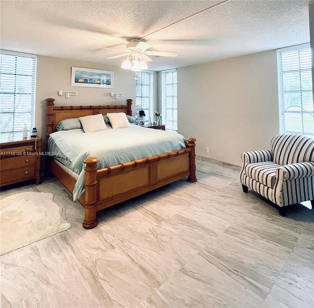 bedroom featuring a ceiling fan and a textured ceiling