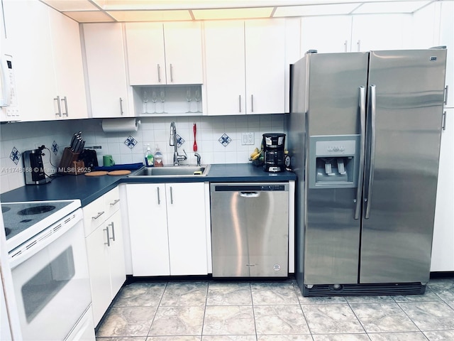 3800 Oaks Clubhouse Dr Unit 112, Pompano Beach, FL 33069 - kitchen featuring appliances with stainless steel finishes, a sink, dark countertops, and decorative backsplash