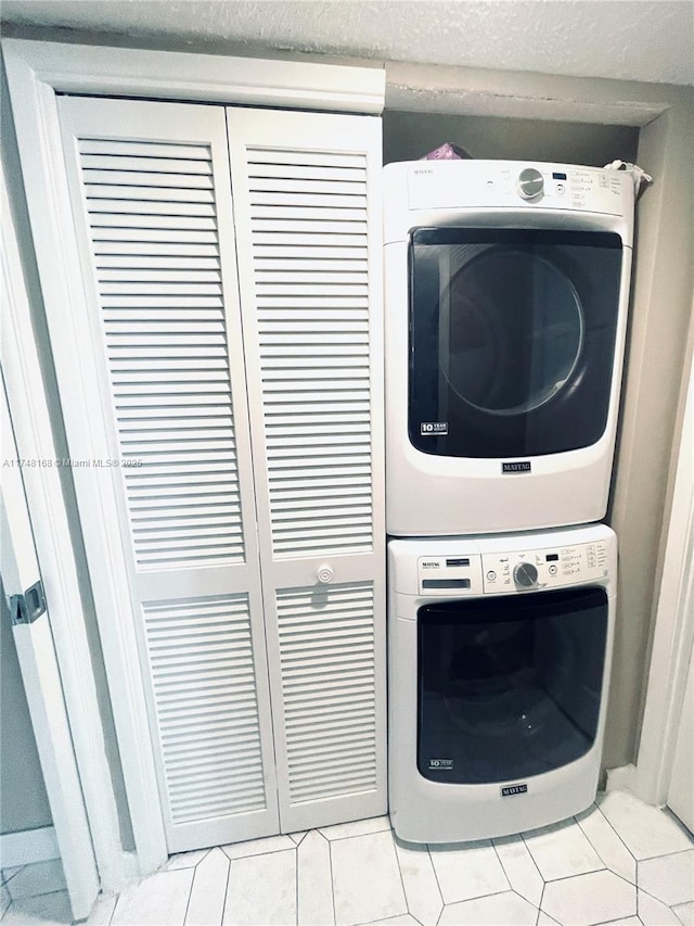 3800 Oaks Clubhouse Dr Unit 112, Pompano Beach, FL 33069 - laundry area featuring stacked washer / drying machine and light tile patterned floors