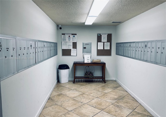 3800 Oaks Clubhouse Dr Unit 112, Pompano Beach, FL 33069 - hall with mail area, a textured ceiling, baseboards, and light tile patterned flooring