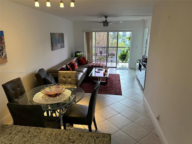 dining room featuring ceiling fan, baseboards, and light tile patterned floors