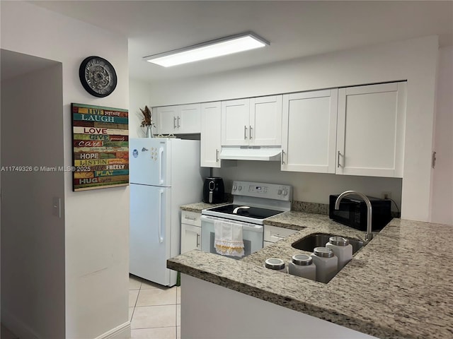 kitchen featuring light tile patterned floors, white cabinets, a sink, white appliances, and under cabinet range hood