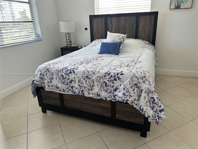 bedroom featuring tile patterned flooring and baseboards