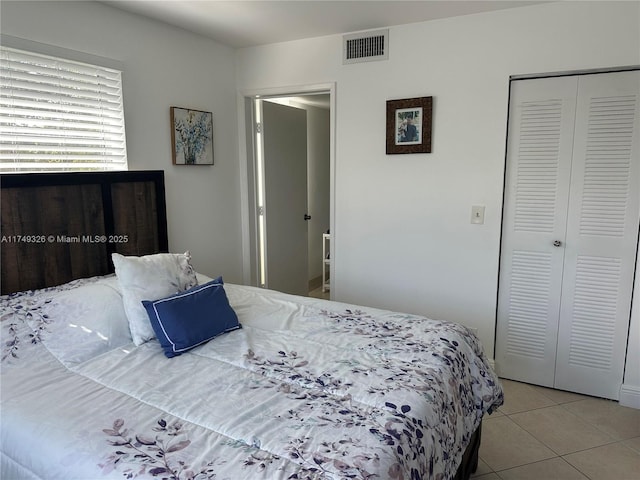 bedroom featuring a closet, visible vents, and light tile patterned floors