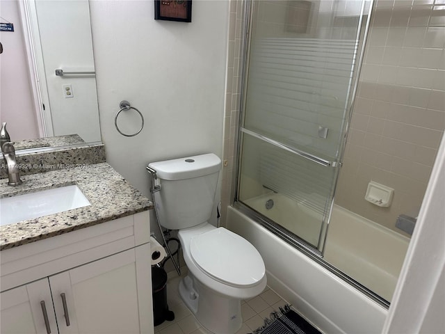 full bath with tile patterned floors, vanity, toilet, and bath / shower combo with glass door