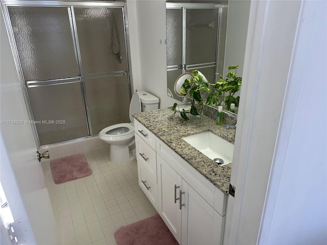 full bath with a shower with door, vanity, toilet, and tile patterned floors