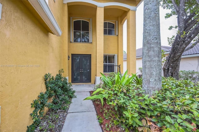 doorway to property featuring french doors and stucco siding