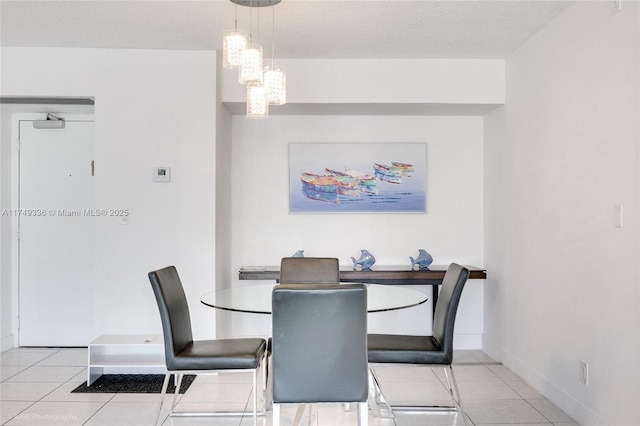 dining room with baseboards, a textured ceiling, and light tile patterned flooring