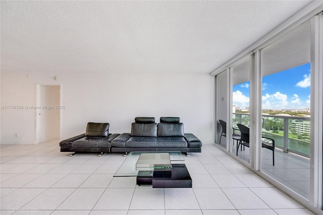 living room featuring expansive windows, a textured ceiling, and light tile patterned flooring