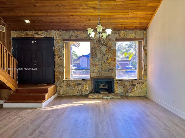 unfurnished living room featuring wooden ceiling, a chandelier, wood finished floors, plenty of natural light, and baseboards
