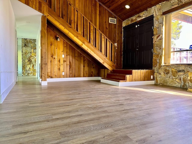 entryway featuring wooden walls, wood finished floors, wood ceiling, vaulted ceiling, and stairway