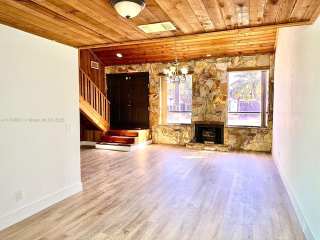 unfurnished living room featuring wooden ceiling, wood finished floors, a chandelier, stairway, and a fireplace