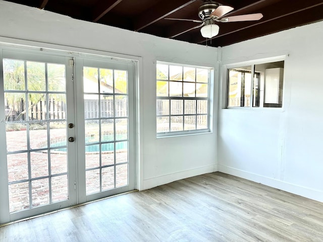 doorway to outside with wood finished floors, a ceiling fan, plenty of natural light, and beamed ceiling