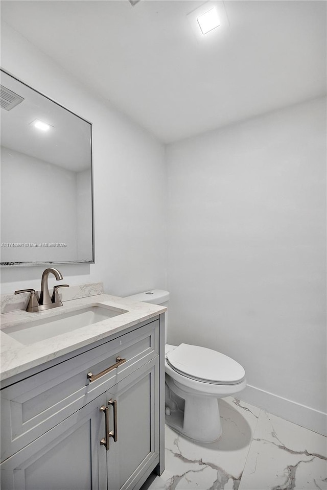 half bath featuring visible vents, baseboards, toilet, marble finish floor, and vanity