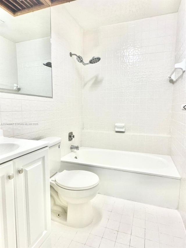 full bathroom featuring tile walls, toilet, vanity, washtub / shower combination, and tile patterned flooring