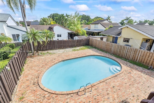 view of swimming pool with a fenced backyard and a residential view
