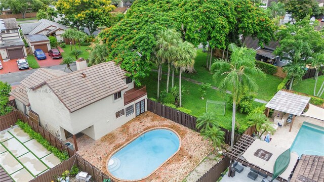 view of swimming pool featuring a fenced backyard, a patio, and an outdoor structure