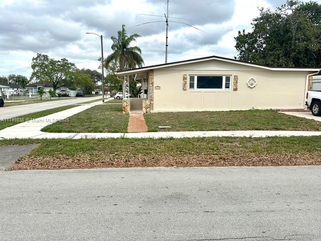 view of front of house with driveway and a front lawn