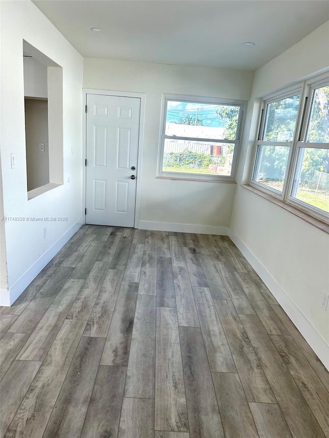 spare room featuring wood finished floors and baseboards