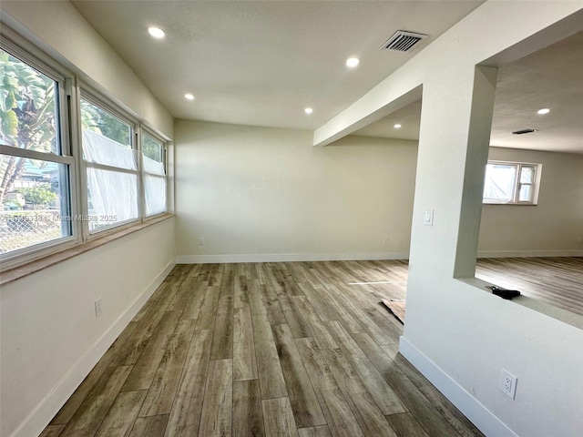 empty room with recessed lighting, visible vents, baseboards, and wood finished floors