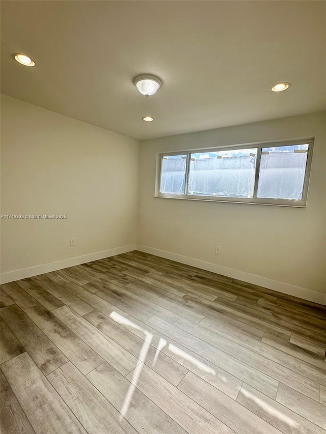 empty room featuring recessed lighting, light wood-style flooring, and baseboards