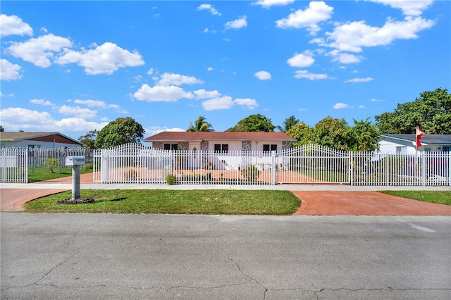 view of front of property featuring a fenced front yard and decorative driveway