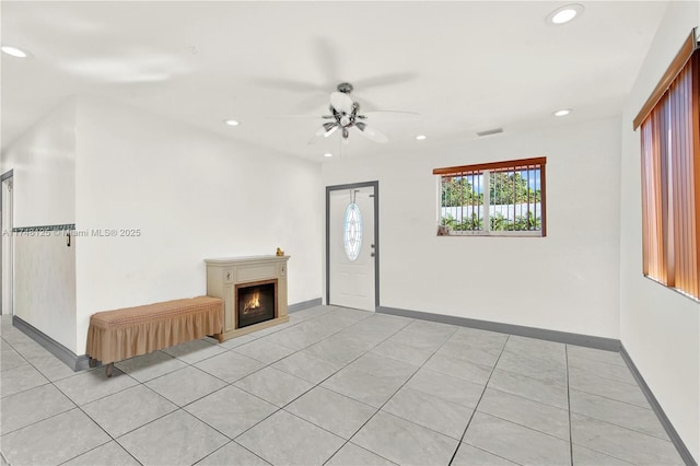 unfurnished living room featuring baseboards, a lit fireplace, visible vents, and recessed lighting