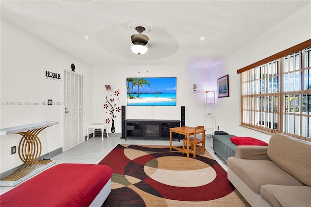 living room with light tile patterned floors, baseboards, and a textured ceiling