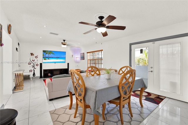 dining space featuring light tile patterned floors, ceiling fan, french doors, and visible vents